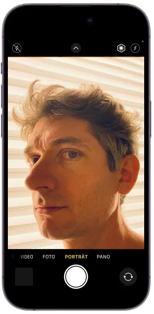 iPhone with camera app displaying Markus Kison's portrait